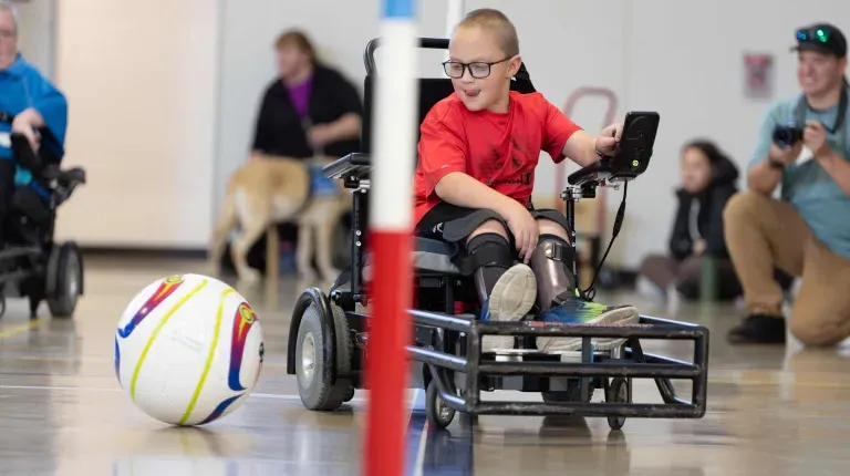 A young boy plays power soccer