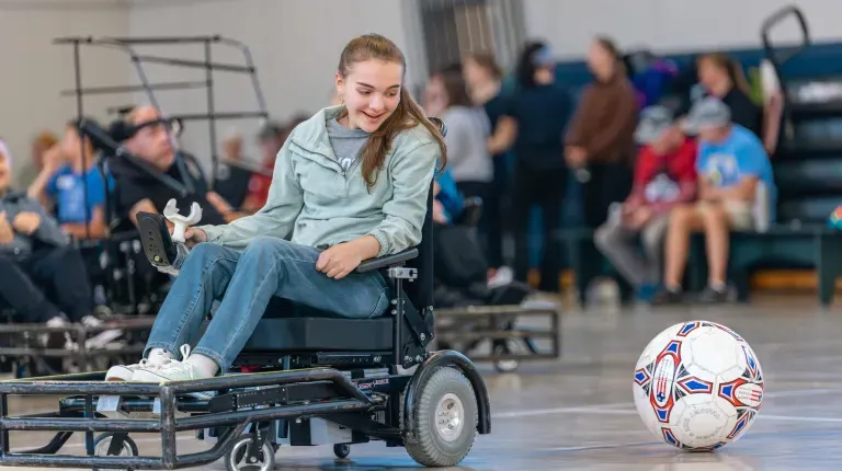 A wheelchair user plays power soccer